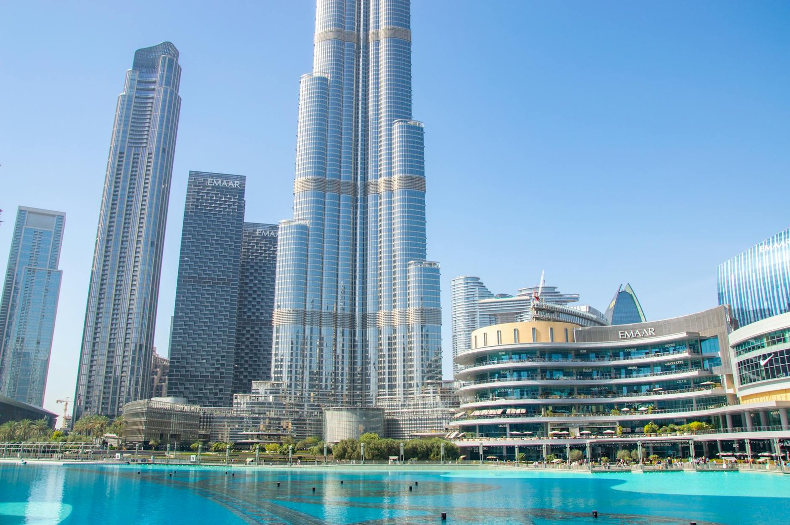 Stunning view of Burj Khalifa and surrounding skyscrapers reflecting in a tranquil pool, Dubai.