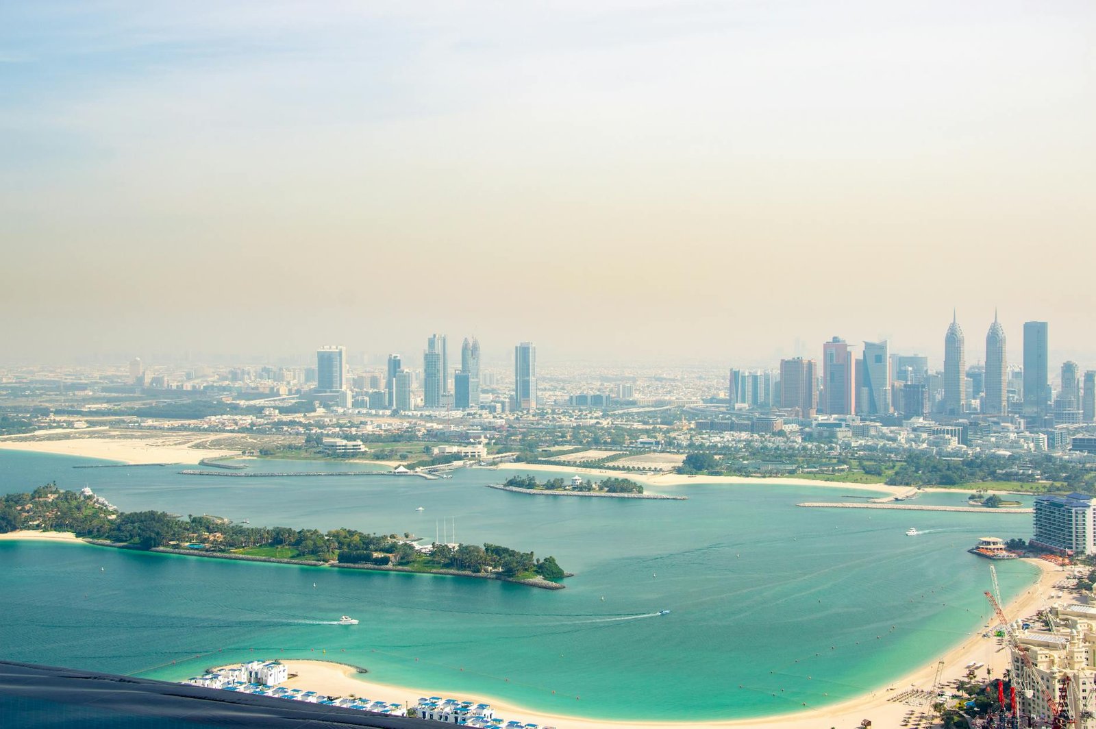 Stunning aerial view of Dubai's skyline with a beautiful coastline and clear blue waters.