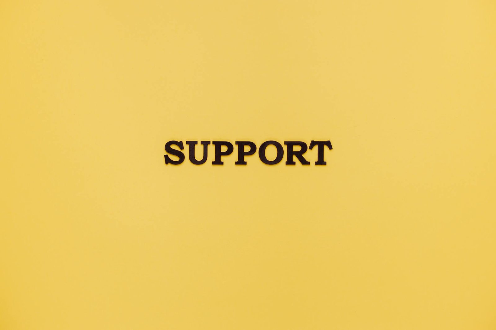 Minimalist image with 'Support' text on a yellow background for conceptual themes.