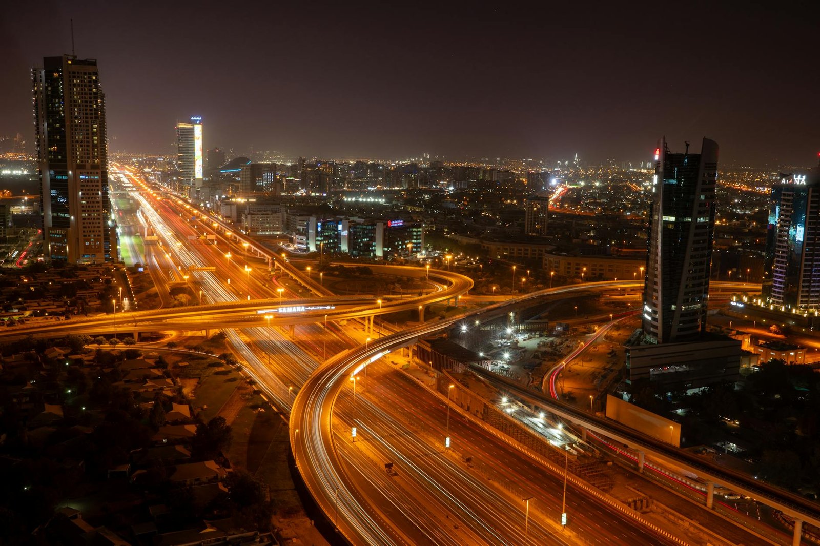 A breathtaking view of Dubai's vibrant skyline and illuminated roads at night, showcasing modern urban architecture.