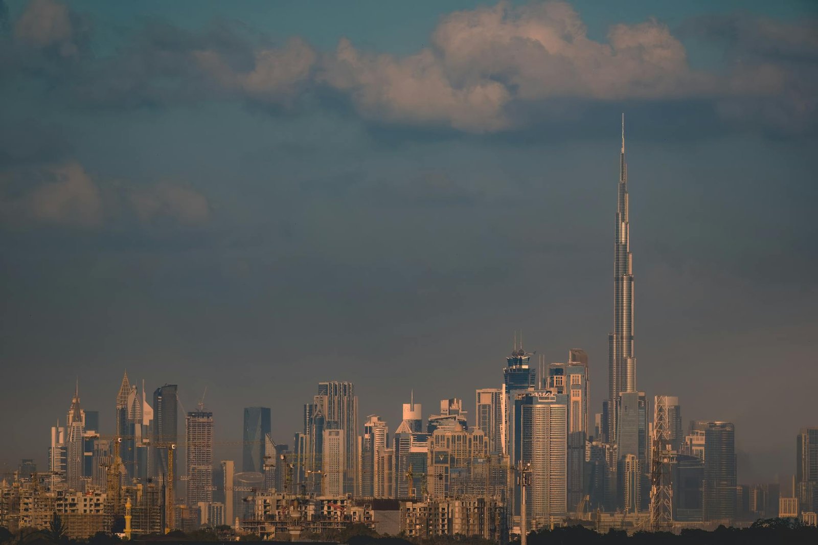 Stunning view of Dubai skyline featuring the famous Burj Khalifa at dusk under a cloudy sky.