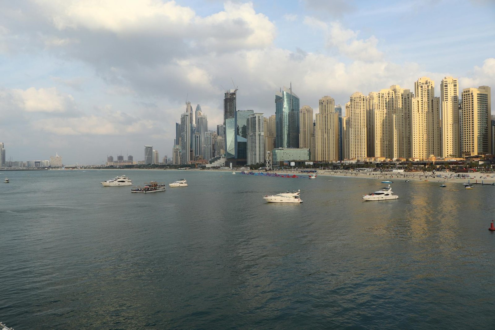 A breathtaking view of Dubai Marina with luxurious skyscrapers and yachts on a sunny day.